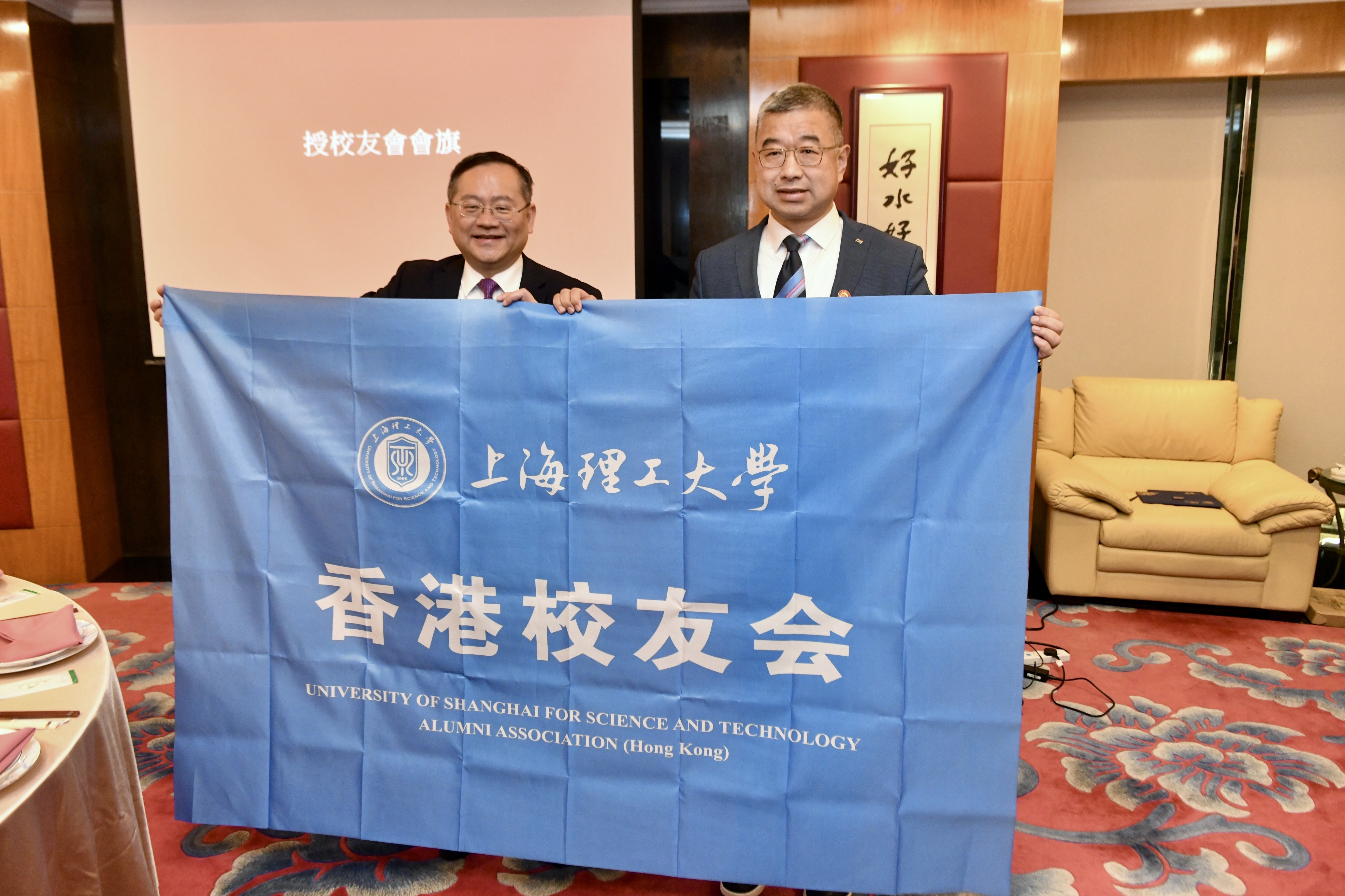 朱新远校长代表学校向王东哲授予校友会会旗